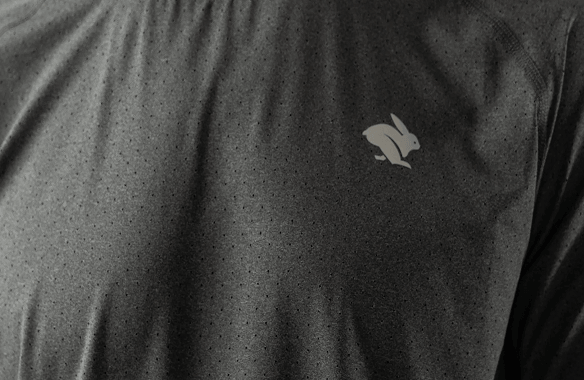 Close-up of gray heathered performance t-shirt with running rabbit logo on chest